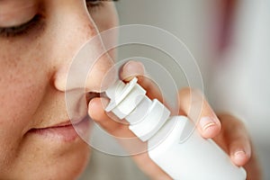 Close up of sick woman using nasal spray