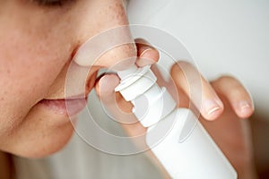 Close up of sick woman using nasal spray