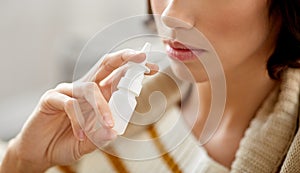 Close up of sick woman using nasal spray photo