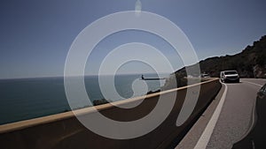 Close up side of car and light on the road. Driving car on the mountain road. Car rides on serpentine. Mediterranean sea