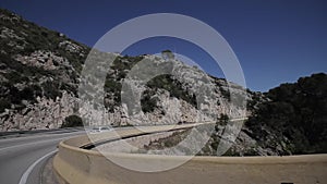 Close up side of car and light on the road. Driving car on the mountain road. Car rides on serpentine. White mountains