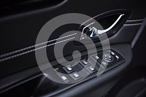 Close-up of the side door buttons: window adjustment buttons, door lock. modern car interior: parts, buttons, knobs