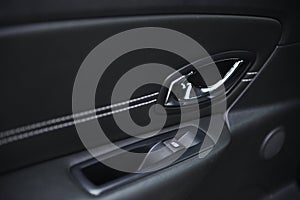 Close-up of the side door buttons: window adjustment buttons, door lock. modern car interior: parts, buttons, knobs