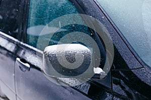 Close-up of side mirror of snow covered blue car