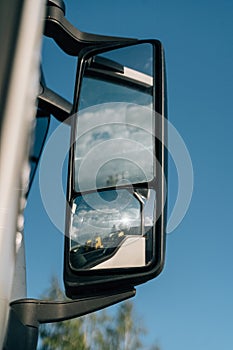 Close up of side mirror of truck car on blue sky background