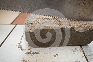 Close up side of a saw cutting a concrete slab placed on a ceram