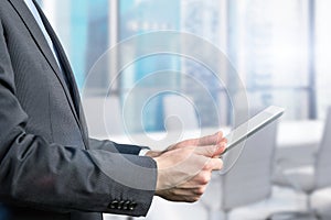 Close-up of side view of a businessman who is browsing on his tablet.