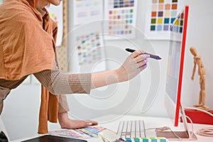 Close-up side view image of a talented female graphic designer working in her studio