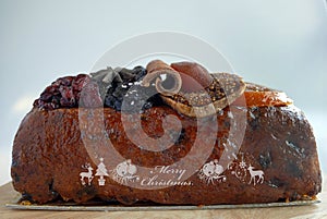 Close-up side view loaf of fruitcakes St-Germain elderflower liqueur seasons cake with Merry Christmas