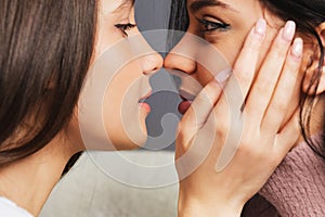 Close up side view photo of two girls in love looking at each other enjoying intimate tender sensual moment together