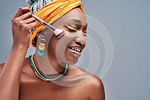 Close up side view portrait of beautiful aro american woman applying makeup with brush