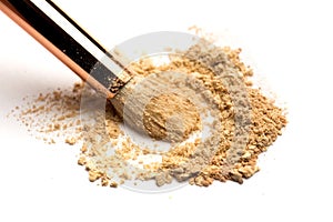 Close-up side view of professional make-up brush with natural bristle and black ferrule with crashed eyeshadow on white