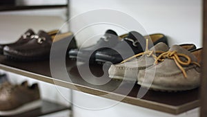 A close up side view shot of a three pairs of moccasins being demonstrated on a shelf for customers of a clothing