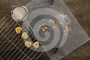 Sieve with icing sugar cookies on cooling rack