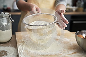 Close up of sifting flour in domestic kitchen