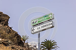 Close-up of signs indicating direction to Puerto Rico Beach and highway towards La Cornisa on island of Gran Canaria.