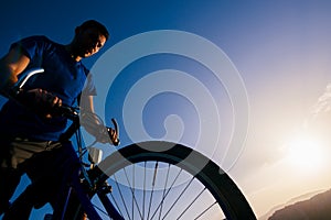 Close up silhouette of an athlete mountain biker riding his bike on rocky mountains