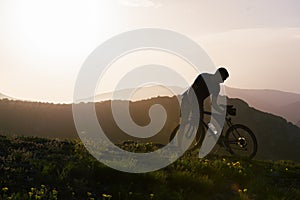 Close up silhouette of an athlete mountain biker riding his bike on rocky mountains