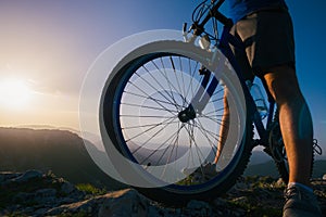 Close up silhouette of an athlete mountain biker riding his bike on rocky mountains