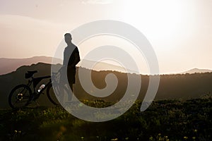 Close up silhouette of an athlete mountain biker riding his bike on rocky mountains