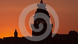 Close up silhouettes of the maidens tower and galata tower in yellow sunset