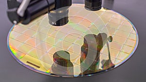 Close up of silicon wafer with microchips on machine process examining in microscope and checking quality . Selective focus