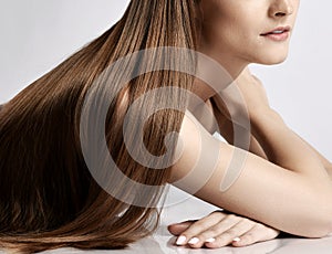 Close-up of silky long straight hair of young beautiful woman model lying and posing