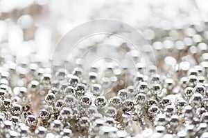 Close up of silver beads on shiny sequined texture