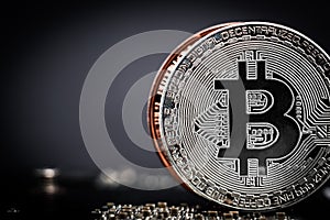 Close-up of silver bitcoin coin on dark background