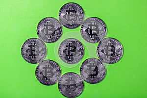 Close-up of silver Bitcoin coins on green background