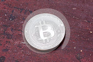 Close up of silver bitcoin on red background, maccro shot.