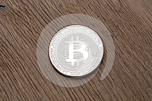 Close up of silver bitcoin on wooden background.