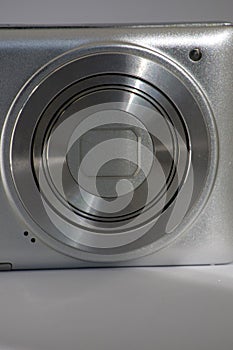 Close-up Silver digital compact camera with a closed lens. space for signature
