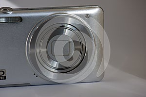 Close-up Silver digital compact camera with a closed lens. space for signature