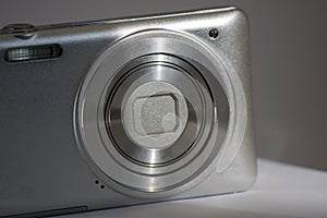 Close-up Silver digital compact camera with a closed lens. space for signature