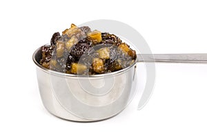 Close up silver measuring cup containing fruit mincemeat mix