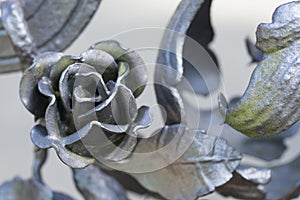 Close up on a silver metal rose, part of a metal fence