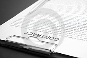 Close-up of a silver pen on docunent contract. Legal contract signing, buy sell real estate contract agreement sign on document