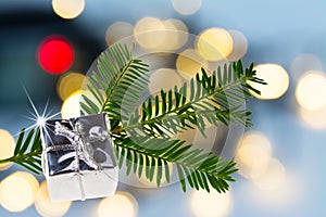 Close-up of silver present on green Christmas branch