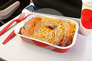 Close-up simple in-flight meal rice, meat, coffee in disposable