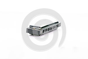 Close-up of a simple metal harmonica in C, isolated on a white background