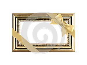 antique gold wood picture frame with diagonal golden ribbon bow wrapping on corner isolated on white background