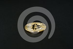 Close up of single Bitcoin with shallow depth of field on black background
