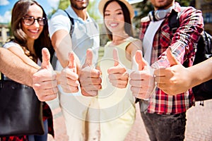 Close up of six like signs of different multi cultural students, gesturing, smiling, standing near each other. They entered