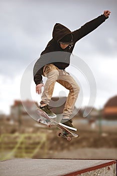 Close up of a skateboarders feet while skating active performance of stunt teenager shot in the air on a skateboard in a