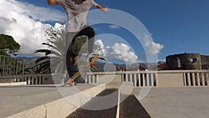Close up of skater skateboarder man doing ollie trick in slow motion, jump over the steps