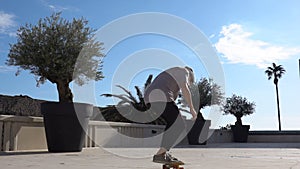 Close up of skater skateboarder man doing ollie trick in slow motion, jump while riding