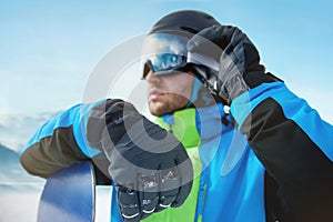 Close Up Of The Ski Goggles Of A Man With The Reflection Of Snowed Mountains. Man In The Background Blue Sky.