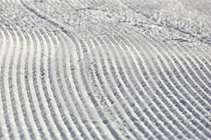 Close-up ski piste, ski slope, Abstract background with tracks on the snow, newly groomed snow