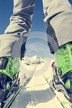 Close up of skier's boots and skis from ground level.